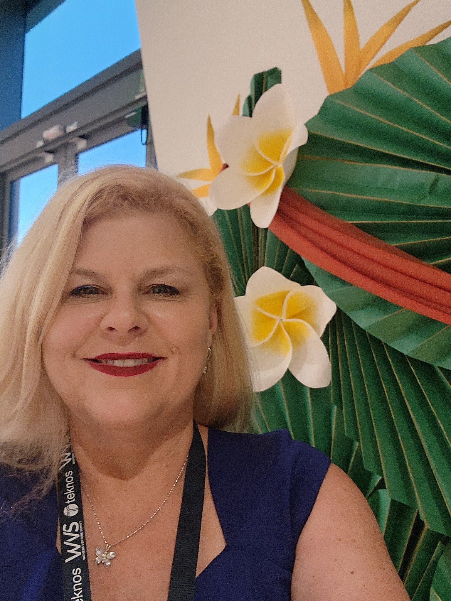 Lisa McCarthy at a conference in front of a tropical flower display